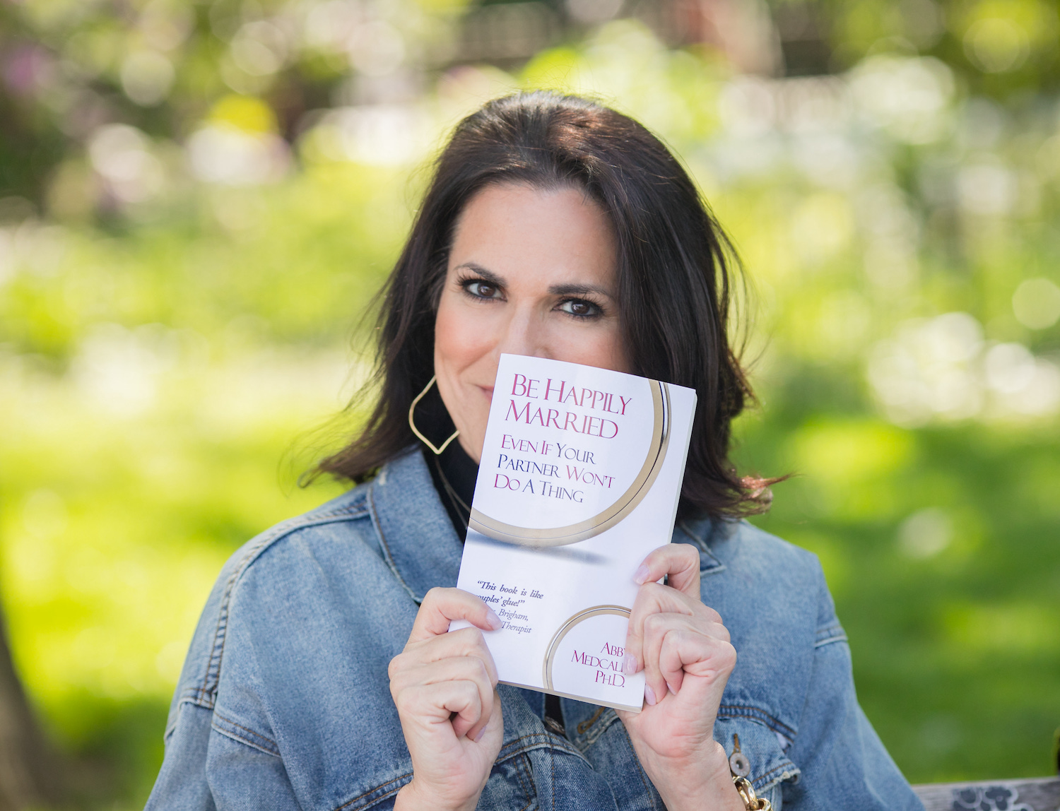 Dr. Abby Medcalf with Her Book Be Happily Married Even If Your Partner Won't Do a Thing